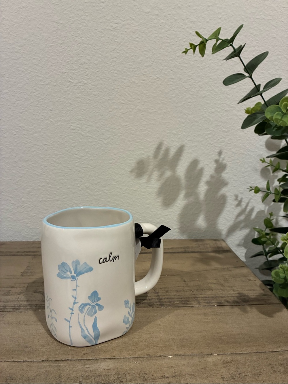 Rae Dunn “calm” mug with light blue flowers.